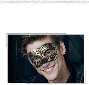 Detail of half-face masquerade mask with ornate gold baroque patterns and black finish