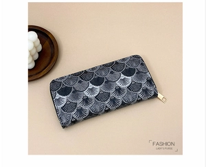 Detail of long wallet showing black and white wave embroidery and golden zipper closure