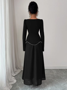 Vue détaillée du dos d'une robe de soirée noire avec ornements de perles à la taille