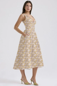 Detail of V-neck floral summer dress featuring yellow fabric and purple flower print