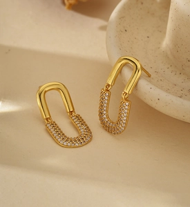 Detail of gold U-shaped earring featuring polished metal and micro-pave zircon crystals