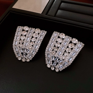 Macro view of silver statement earrings with sparkling baguette-cut zircons on black leather