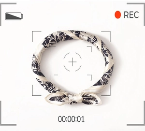 Detail of premium silk scarf featuring retro damascus floral print on creamy white base