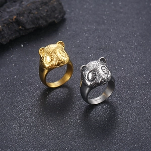 Realistic panda-shaped rings in gold and silver finish on a dark stone background