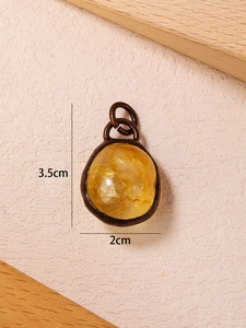 Detail view of raw citrine pendant in bronze frame with 3.5cm by 2cm dimensions