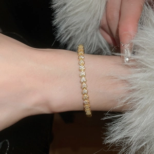 Détail du bracelet cœur plaqué or 18 carats avec oxydes de zirconium brillants au poignet
