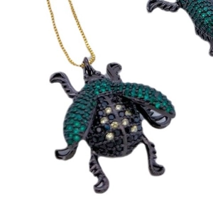 Black insect beetle necklace pendant with green and yellow zircons on gold chain