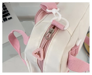 Detail of white nylon bag with pink zipper and plastic swivel hook attachment