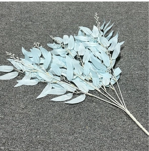 Detailed close-up of light blue artificial willow leaves with white stems on grey surface
