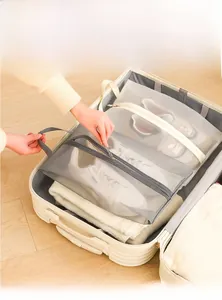 Detail of travel shoe storage bags with mesh window and handle on a light wood floor