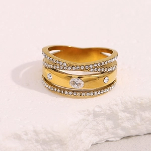 Close-up of multi-layer 18K gold plated ring with micro-pave cubic zirconia on stone texture