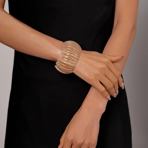 Gros plan d'un bracelet vintage en acrylique marbré beige au design segmenté élastique