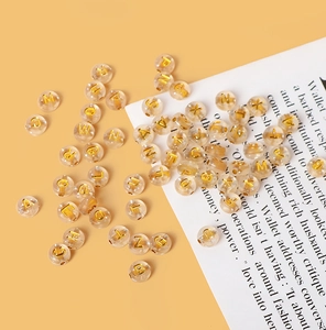 Detailansicht klarer Acrylperlen mit goldenen Buchstaben für DIY-Schmuckherstellung