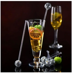 Disco ball cocktail stirrer with silver mirror ball and clear acrylic rod on black background