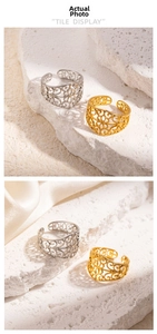 Detail view of gold and silver hollow lace rings on stone and silk background