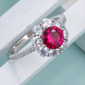 Elegant silver ring featuring a large round red gemstone surrounded by a sparkling halo