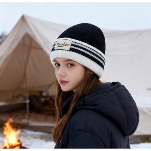 Détail du bonnet en tricot rayé noir et blanc avec patch PineCrest en camping d'hiver