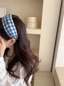 Detail of blue plaid headband with cherry embroidery on soft fabric for women