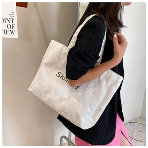 Detail of waterproof PVC layered white canvas tote bag with green letter printing