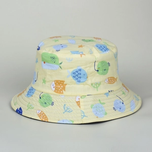 Detail of a yellow cotton bucket hat with colorful whale and sea life cartoon prints