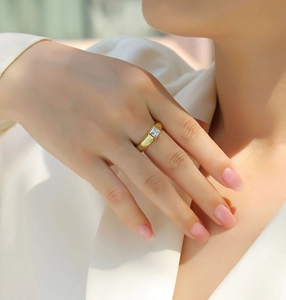 Close-up of gold-plated silver ring featuring a square-cut moissanite stone on finger