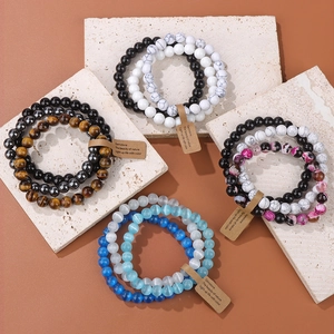 Flat lay of multi-layered gemstone beaded bracelets with amethyst and turquoise on stone