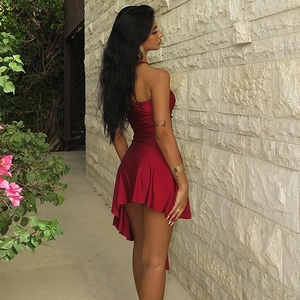 Detail of elegant dark red satin mini dress featuring backless design and irregular hemline