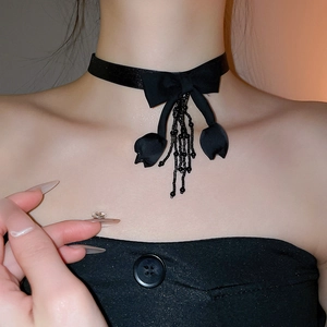 Close-up of black fabric choker with bow design and crystal tassel detailing