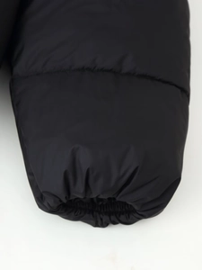 Detailed close-up of elastic ribbed cuffs on a black oversized hooded puffer jacket