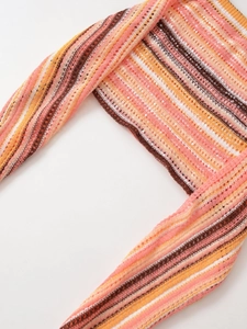 Nahaufnahme von bunt gestreiftem Strickstoff mit Pailletten und Häkelstruktur