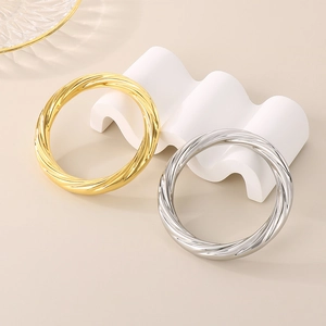 Detail of twisted spiral 10mm stainless steel bangles in gold and silver finishes