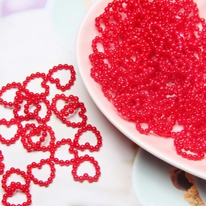 Macro shot of red heart-shaped pearl beads for DIY craft nail art and phone case deco