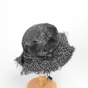 Detail of washed black denim bucket hat with frayed edges and distressed fringe trim