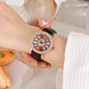 Detail of rose gold watch bezel with rhinestones and colored gemstone floral dial pattern