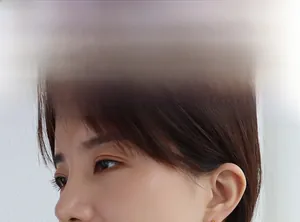 Gros plan d'une boucle d'oreille dorée minimaliste portée par un mannequin en détail