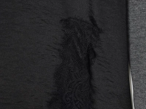 Gros plan sur le tissu noir avec des détails de dentelle de cils sur une robe chic