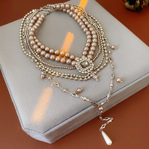 Detail of layered pearl necklace with square crystal pendant and water drop pearl