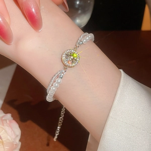 Nahaufnahme des zweilagigen Perlenarmbands mit glitzerndem Zirkonstern am Handgelenk
