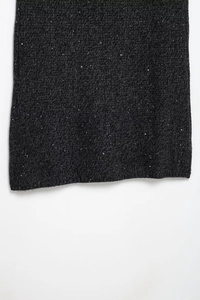 Detailed texture of dark grey knit fabric with shiny silver sequins for dress making