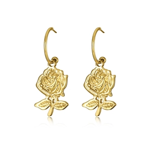 Detailed close-up of golden rose pendant earrings with a high-polish metallic finish