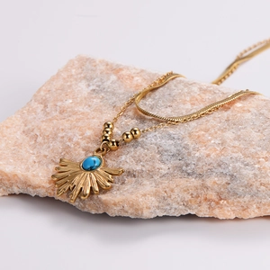 French vintage gold sunburst necklace with turquoise pendant on textured stone