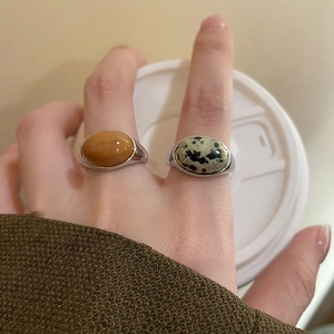 Macro detail of minimalist oval gemstone rings with yellow and speckled stones