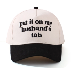Detail of embroidery on two-tone cotton baseball cap with adjustable buckle closure