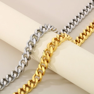 Detail of 13mm gold and silver Cuban link chains draped on a minimalist display