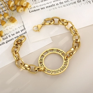 Chunky gold chain bracelet with Roman numeral pendant next to dried flowers on a book