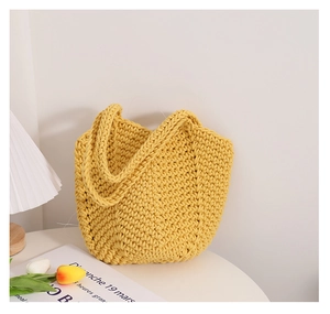 Detailed knit texture of the yellow cotton woven handbag in a cozy home setting