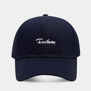 Detailed close-up of white Forever embroidery on a navy blue cotton baseball cap