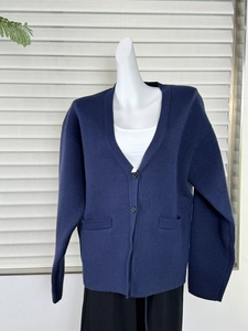 Detailed front view of navy blue V-neck knit cardigan with large pockets and buttons