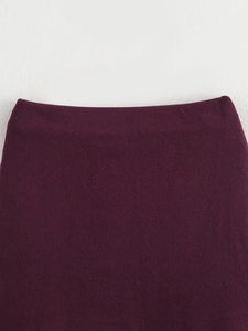 Close-up of deep purple knit vest waistline showing fine texture and smooth tailoring