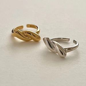 Detailed view of gold and silver knot rings showing the S925 sterling silver stamp